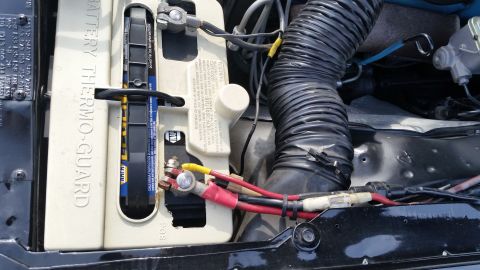 1991 Ford LTD Crown Victoria - Photograph of a Thermo-Guard battery with terminal cables and intake ducting in an engine bay, not a technical document.