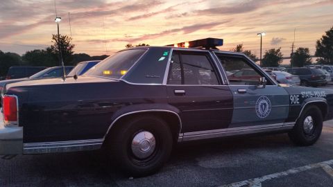 1991 Ford LTD Crown Victoria - Photograph of a State Police sedan cruiser parked at sunset, not a technical document.