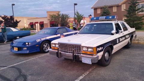 1991 Ford LTD Crown Victoria - Photograph of a State Trooper Camaro and a Boston Police sedan parked together, not a technical document.