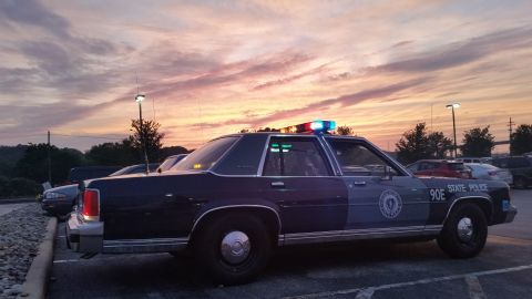 1991 Ford LTD Crown Victoria - Photograph of a State Police sedan cruiser parked at sunset, not a technical document.
