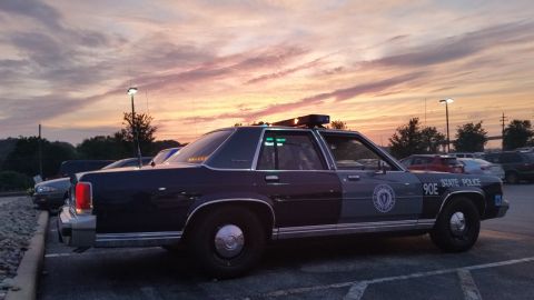 1991 Ford LTD Crown Victoria - Photograph of a State Police sedan cruiser at sunset, side view, not a technical document.