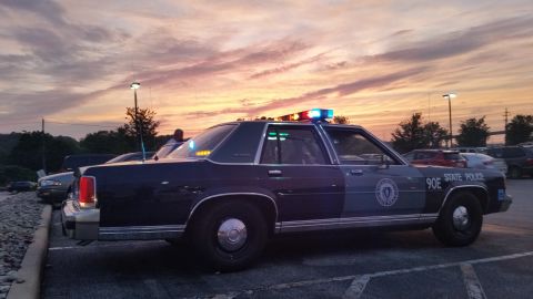 1991 Ford LTD Crown Victoria - Photograph of a State Police sedan cruiser at sunset, rear three-quarter view, not a technical document.