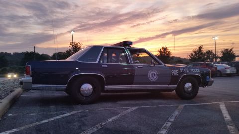 1991 Ford LTD Crown Victoria - Photograph of a State Police sedan cruiser at dusk, side view, not a technical document.