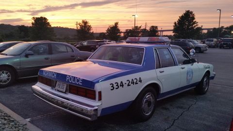 1991 Ford LTD Crown Victoria - Photo of a vintage Norwich Police Chevrolet Caprice patrol car at dusk, not a technical document.