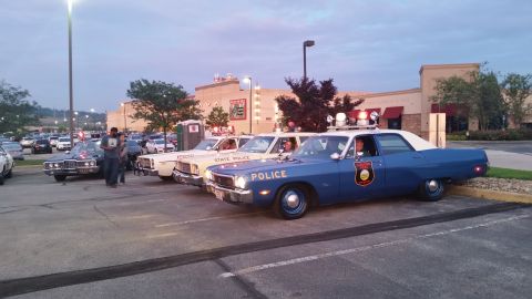 1991 Ford LTD Crown Victoria - Photo of a lineup of vintage police cars at a car meet, not a technical document.