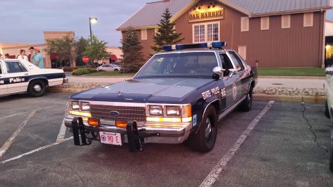 1991 Ford LTD Crown Victoria - Photo of a vintage State Police Ford patrol car at dusk, not a technical document.
