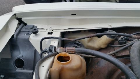 1991 Ford LTD Crown Victoria - Photo of an engine bay showing washer reservoir and coolant overflow bottle, not a technical document.