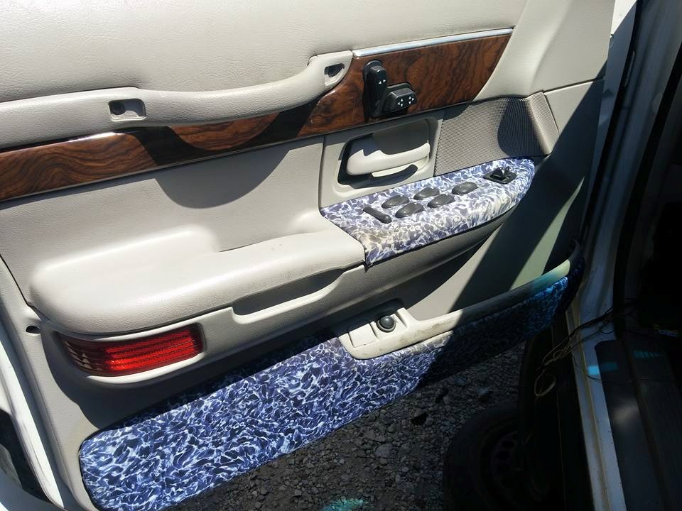 Interior door panel with woodgrain trim and water-spotted armrest