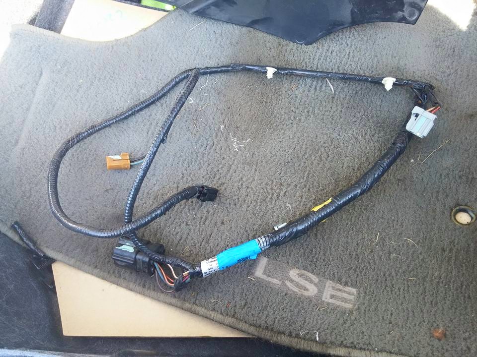 Removed wiring harness with connectors lying on an LSE floor mat