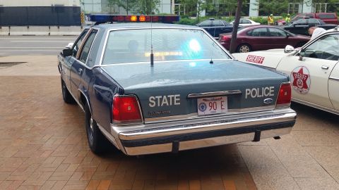 1991 Ford LTD Crown Victoria - Photograph of the rear of a Massachusetts State Police Ford cruiser at a car show, not a technical document.