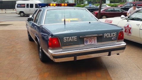 1991 Ford LTD Crown Victoria - Photograph of the rear of a blue State Police Ford cruiser with lights on, not a technical document.