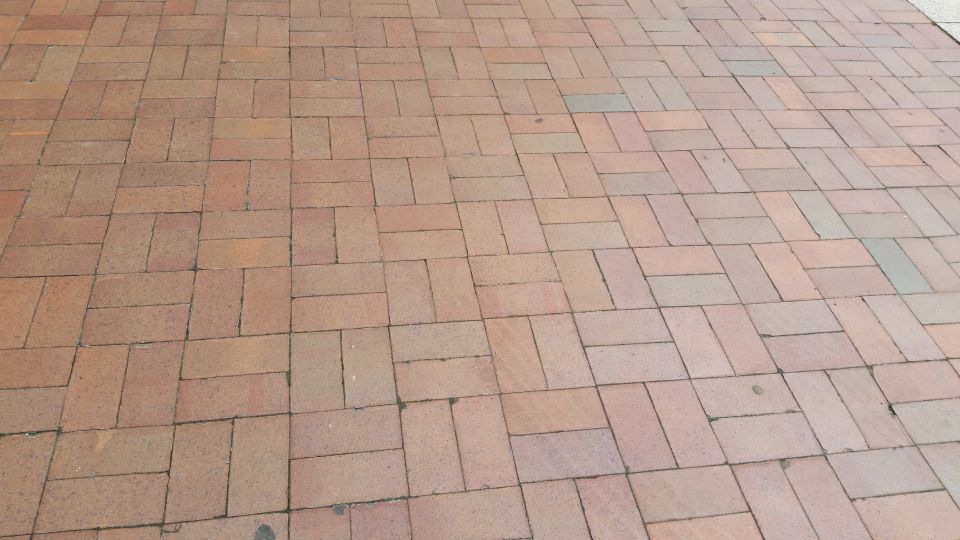 Close-up of red herringbone-pattern brick pavement