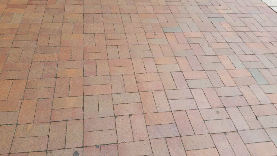 Close-up of red brick pavement in herringbone pattern
