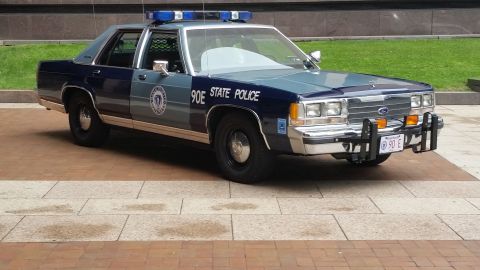 1991 Ford LTD Crown Victoria - Photograph of a Massachusetts State Police Ford cruiser with brush guard, not a technical document.