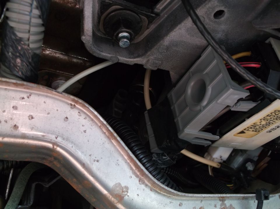 Gray electrical connector housing with wiring and a yellow label.