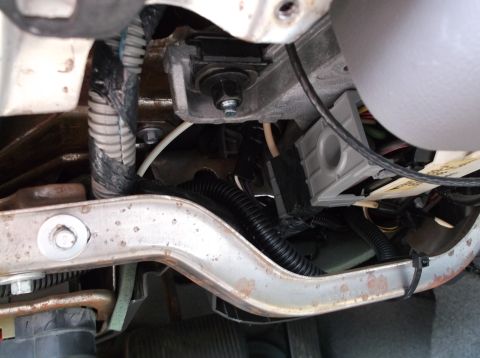 1999 Mercury Grand Marquis - This image shows a close-up view of the under-dash area of a vehicle, focusing on wiring harnesses, a metal bracket, and some electrical co…