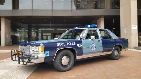 1991 Ford LTD Crown Victoria - Photo of a Massachusetts State Police Ford Crown Victoria cruiser, unit 90E, parked outside a building.