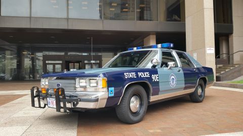 1991 Ford LTD Crown Victoria - Photo of a Massachusetts State Police Ford Crown Victoria cruiser, unit 90E, parked outside a building.