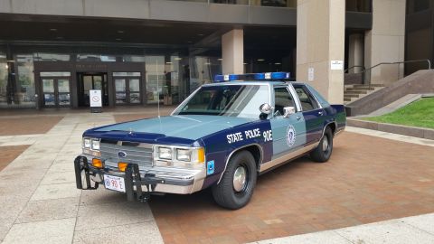 1991 Ford LTD Crown Victoria - Photo of a Massachusetts State Police Ford Crown Victoria cruiser, unit 90E, at a building plaza.