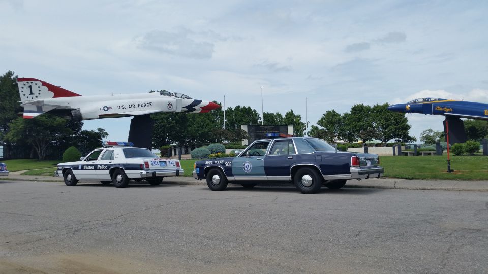 Boston Police and State Police cruisers parked near a display jet aircraft
