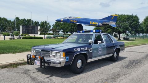 1991 Ford LTD Crown Victoria - Photo of a Massachusetts State Police Ford Crown Victoria cruiser, unit 90E, near a U.S. Navy Blue Angels display jet.