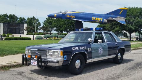1991 Ford LTD Crown Victoria - Photo of a Massachusetts State Police Ford Crown Victoria cruiser, unit 90E, near a U.S. Navy Blue Angels display jet.