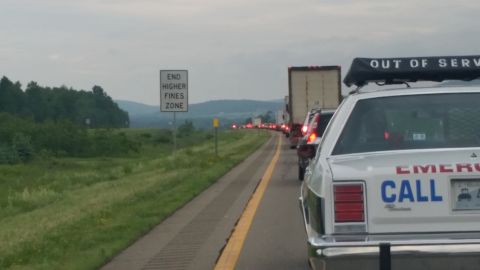 1991 Ford LTD Crown Victoria - Photograph of stopped highway traffic and an 'End Higher Fines Zone' sign beside an emergency vehicle.