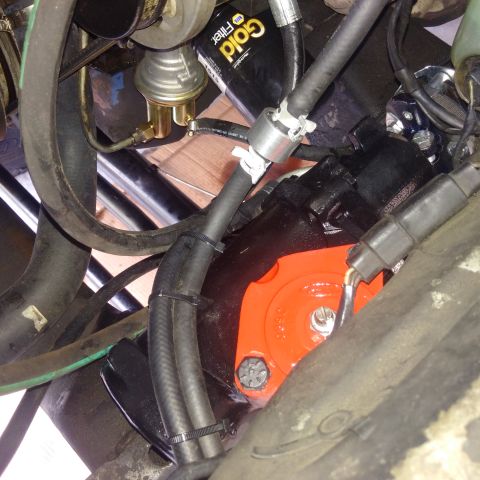 1978 Ford Bronco - Close-up view of engine components, including a black power steering pump with an orange bracket, various hoses, and a Gold Filter oil filt…