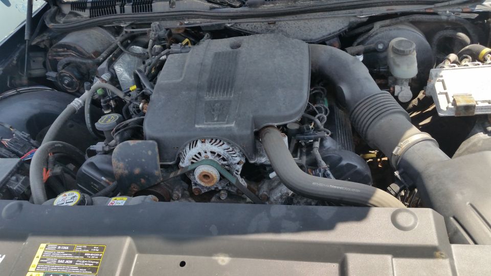 Engine bay of a Ford Crown Victoria with intake and alternator