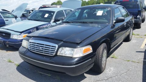 2001 Ford Crown Victoria - Photograph of the front of a black Ford Crown Victoria parked in an auction lot, not a technical document.