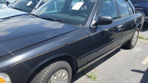 2001 Ford Crown Victoria - Photograph of the driver-side profile of a black Crown Victoria sedan, not a technical document.