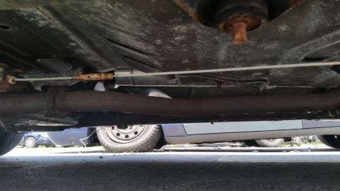 2001 Ford Crown Victoria - Photograph of a vehicle undercarriage showing exhaust pipe and frame components, not a technical document.