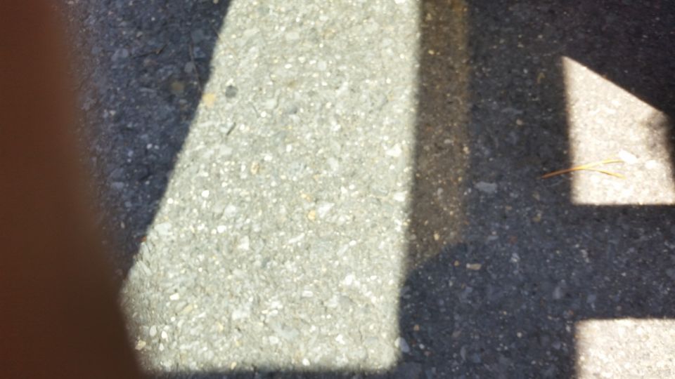 Blurry photo of asphalt pavement with shadow