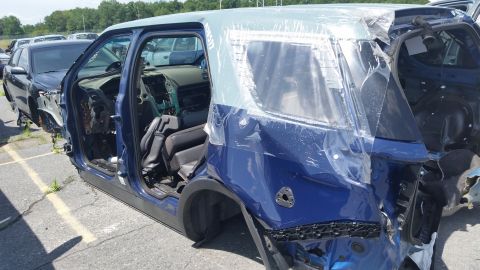 2001 Ford Crown Victoria - Photograph of a crash-damaged blue SUV at a salvage yard, not a technical document.