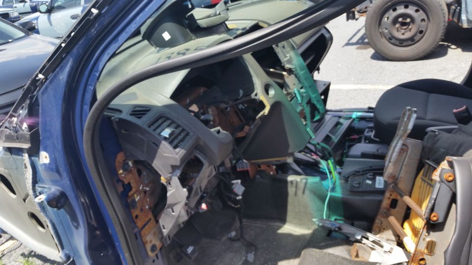 Photo of a stripped vehicle interior showing exposed dashboard and wiring