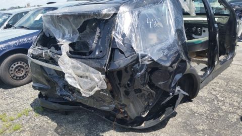 2001 Ford Crown Victoria - Photograph of a crash-damaged black SUV at a salvage yard, not a technical document.