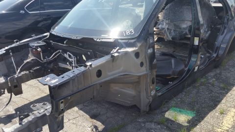 2001 Ford Crown Victoria - Photograph of a dismantled dark vehicle body at a salvage yard, not a technical document.