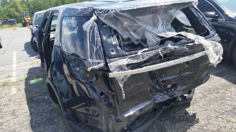 2001 Ford Crown Victoria - Photograph of a crash-damaged black SUV at a salvage yard, not a technical document.