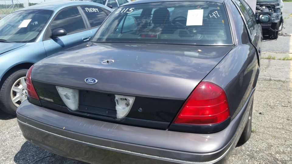 Photo of the rear of a gray Ford Crown Victoria sedan in a lot