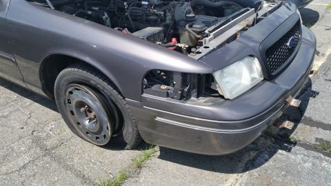 2001 Ford Crown Victoria - Photograph of a partially dismantled gray Ford sedan front end, not a technical document.