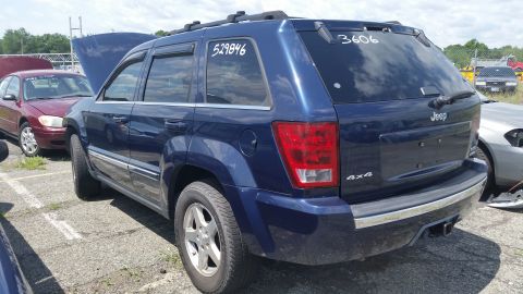 2001 Ford Crown Victoria - Photograph of the rear of a blue Jeep Grand Cherokee at a salvage lot, not a technical document.
