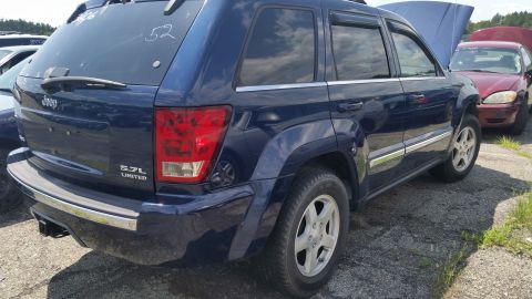 2001 Ford Crown Victoria - Photograph of the rear quarter of a blue Jeep Grand Cherokee, not a technical document.