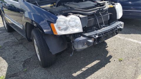 2001 Ford Crown Victoria - Photograph of a partially dismantled blue Jeep front end, not a technical document.