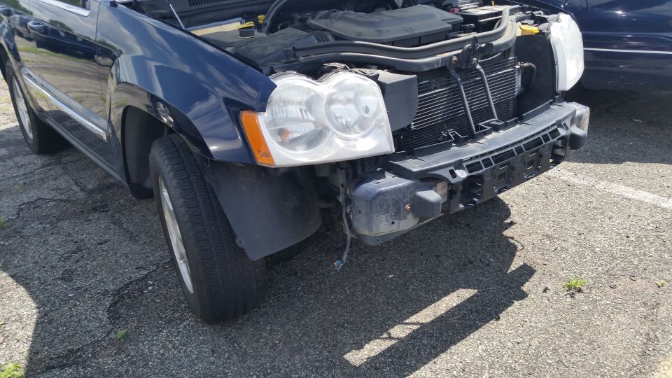 Photo of a blue Jeep Grand Cherokee front end with bumper and grille removed