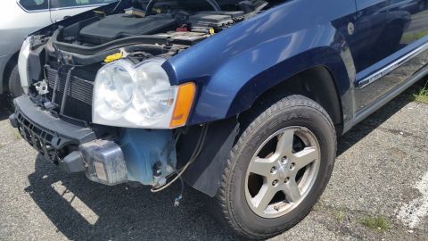 2001 Ford Crown Victoria - Photograph of a partially dismantled blue Jeep front corner, not a technical document.