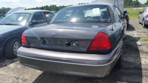 2001 Ford Crown Victoria - Photograph of the rear of a gray Ford sedan with trunk hardware removed, not a technical document.
