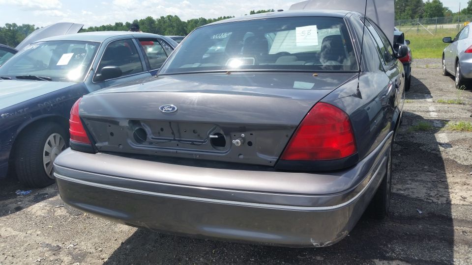 Photo of the rear of a gray Ford Crown Victoria with trunk lid hardware removed