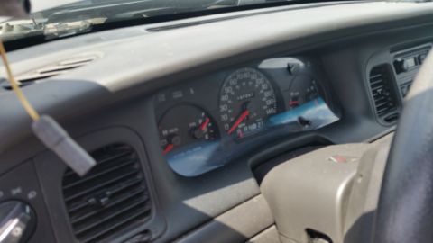 2001 Ford Crown Victoria - Photo of a Ford Crown Victoria gauge cluster and dashboard seen through the windshield.
