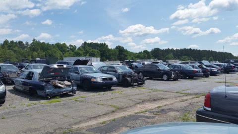 2001 Ford Crown Victoria - Photo of a salvage lot filled with rows of disassembled Ford Crown Victoria sedans.