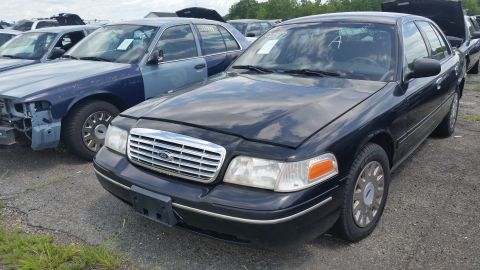 2001 Ford Crown Victoria - Photo of a black Ford Crown Victoria sedan parked among other salvage cars.